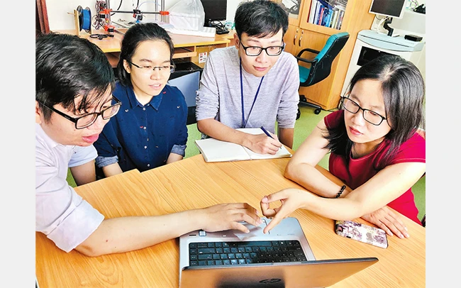 Tiến sĩ Hà Thị Thanh Hương (áo đỏ) hướng dẫn sinh viên Trường đại học Quốc tế TP Hồ Chí Minh nghiên cứu đề tài.