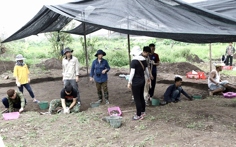GS Lâm Mỹ Dung ( đứng thứ 3 từ trái sang) và TS Nguyễn ANh Thư (áo đen đứng) tại di chỉ khảo cổ Vườn Chuối.