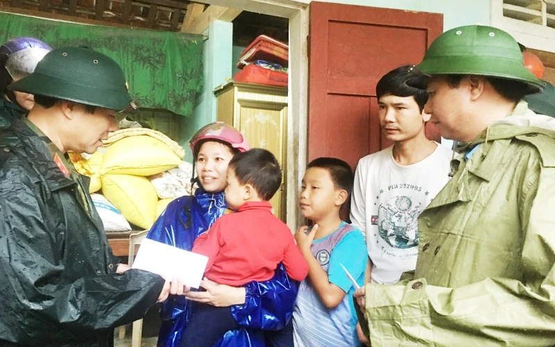 Thứ trưởng Quốc phòng Nguyễn Tân Cương (bên trái) cùng Chủ tịch UBND tỉnh Quảng Trị Võ Văn Hưng thăm, tặng quà cho hộ dân xã Triệu Thành, huyện Triệu Phong.