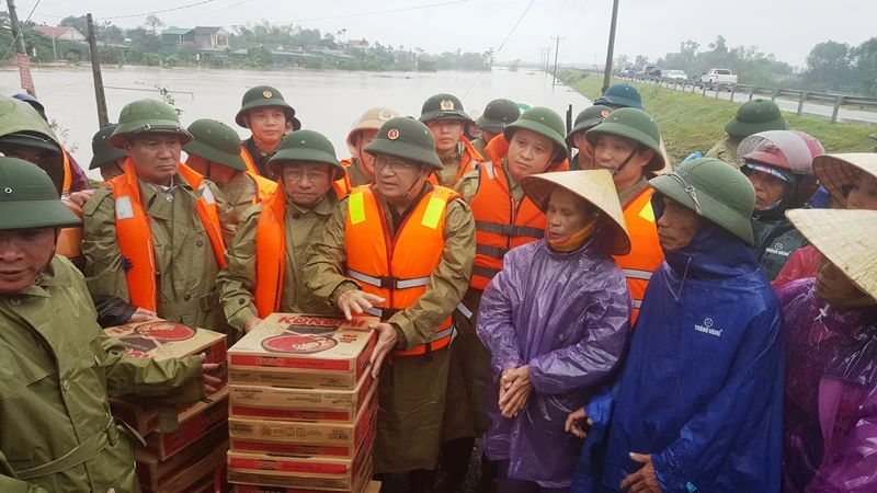 Phó Thủ tướng Trịnh Đình Dũng động viên và trao quà cho người dân vùng lũ.