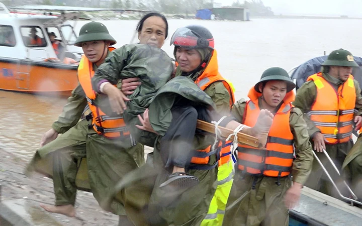 Công an thị xã Ba Đồn (Quảng Bình) khẩn trương đưa người bị thương trong lũ đến bệnh viện cấp cứu.