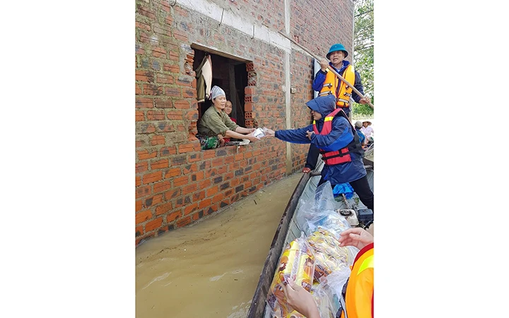 Cán bộ Trung tâm Y tế huyện Lệ Thủy cung cấp viên xử lý nguồn nước cho người dân khi lũ bắt đầu rút dần. 