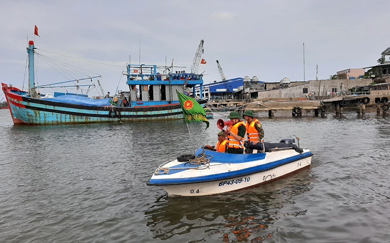 Lực lượng Bộ đội Biên phòng tỉnh Quảng Nam hướng dẫn, giúp người dân đưa tàu thuyền vào nơi trú ẩn an toàn. Ảnh: TẤN NGUYÊN