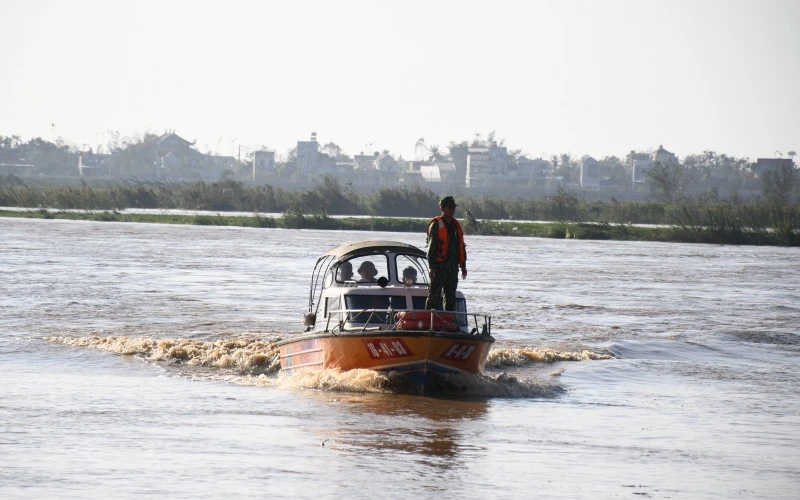 Lực lượng chức năng sử dụng cano đưa công nhân mắc kẹt giữa sông Trà Khúc vào bờ.