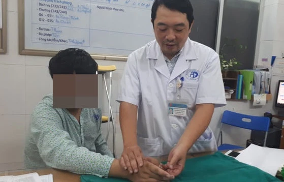 BS Nguyễn Vũ Hoàng – Phó trưởng Khoa phẫu thuật tạo hình (Bệnh viện Xanh Pôn) đang kiểm tra lại tay cho bệnh nhân trước khi xuất viện.