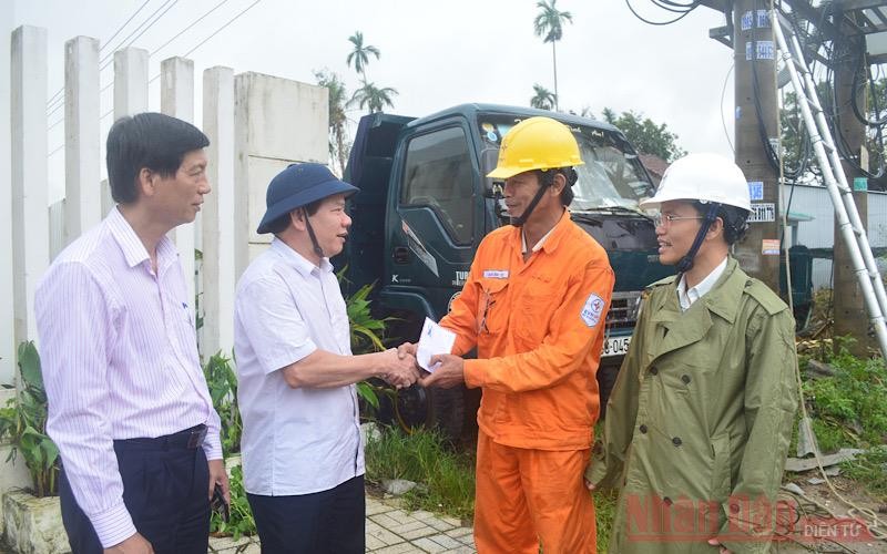 Chủ tịch UBND tỉnh Quảng Ngãi Đặng Văn Minh (thứ hai từ trái sang) động viên công nhân ngành điện vượt qua khó khăn trong việc khôi phục lưới điện bị hư hỏng. (Ảnh: HIỂN CỪ)