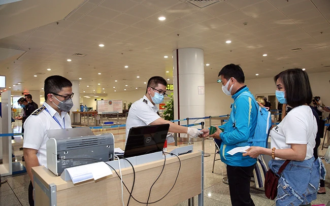 Hành khách thực hiện khai báo y tế trước khi làm thủ tục nhập cảnh tại cửa khẩu Sân bay quốc tế Nội Bài (Hà Nội). Ảnh: DƯƠNG GIANG (TTXVN) 