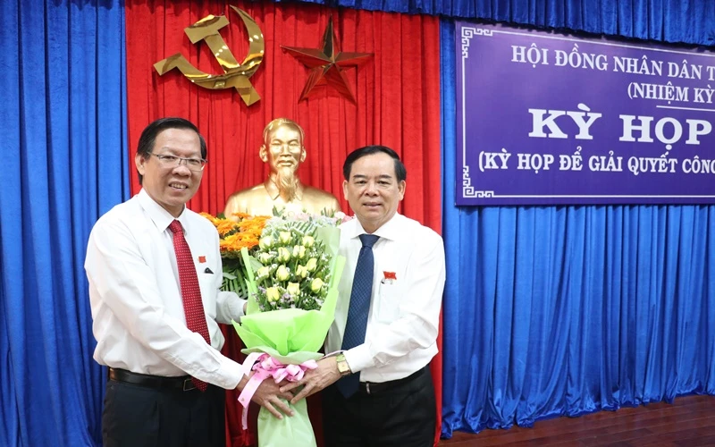 Đồng chí Phan Văn Mãi, Ủy viên T.Ư Đảng, Bí thư Tỉnh ủy (trái) tặng hoa chúc mừng đồng chí Trần Ngọc Tam.
