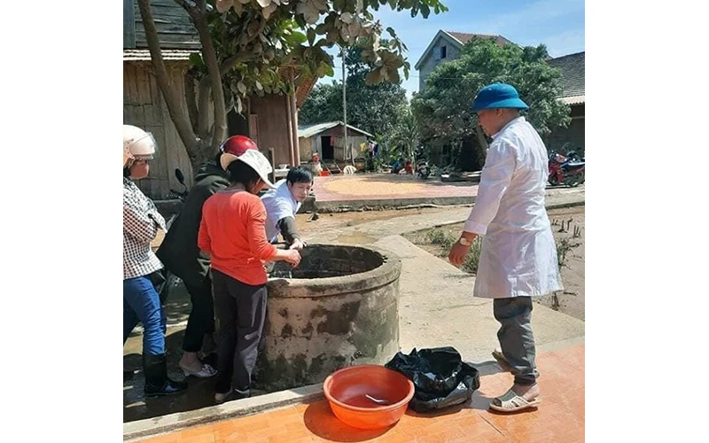 Cán bộ Trung tâm Y tế huyện Minh Hóa (Quảng Bình) hướng dẫn người dân xử lý nguồn nước phục vụ sinh hoạt. Ảnh: HƯƠNG GIANG