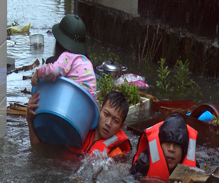Cán bộ, chiến sĩ Lữ đoàn 873 cứu một cháu bé ra khỏi ngôi nhà bị ngập sâu gần 2 m tại phường Bến Thủy, TP Vinh. Ảnh: Trần Dũng (Báo Quân khu 4) 