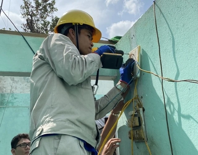 Đoàn viên công nhân EVNHCMC đang sửa chữa điện cho các hộ dân ở Quảng Nam, khắc phục hậu quả cơn bão số 9.