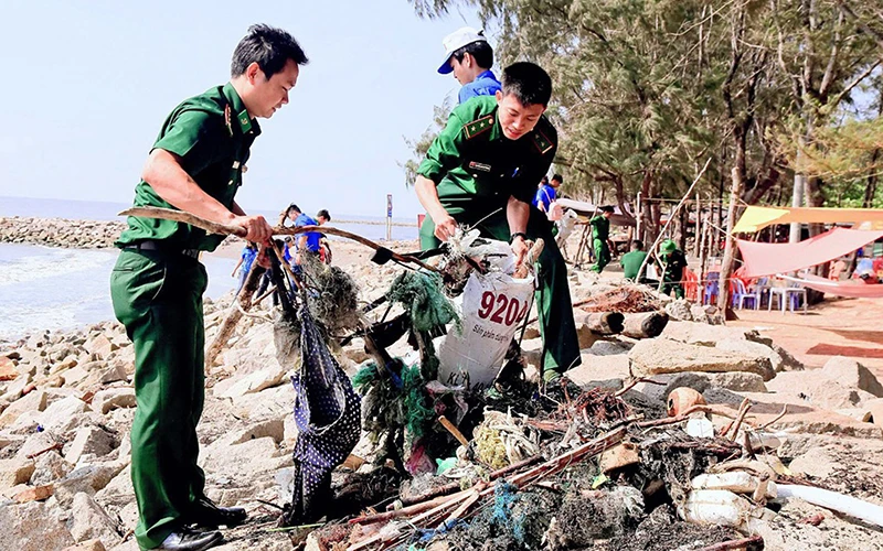 Bộ đội Biên phòng TP Hồ Chí Minh phối hợp đoàn viên, thanh niên nhặt rác tại bãi biển Cần Giờ. Ảnh: KIM ANH