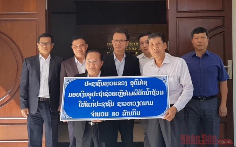 Đồng chí Somchit Panyasack (trái) trao 80 triệu kíp Lào ủng hộ nhân dân miền trung Việt Nam bị ảnh hưởng bởi bão lũ.