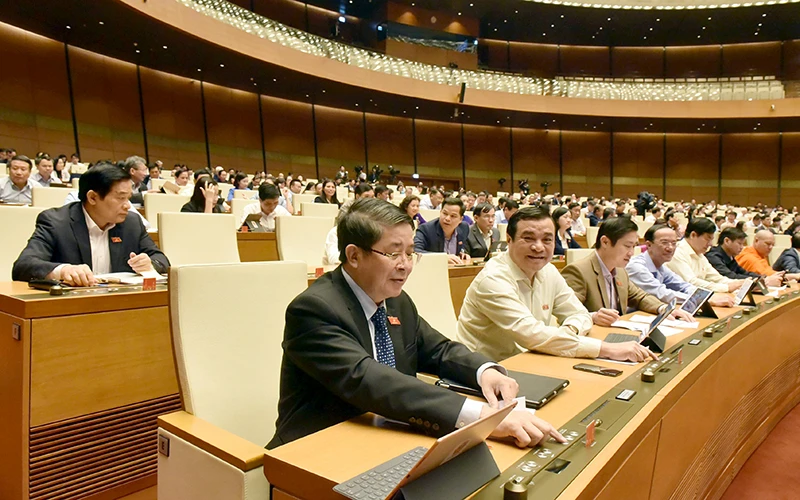 Các đại biểu biểu quyết thông qua Nghị quyết về kế hoạch phát triển kinh tế - xã hội năm 2021. Ảnh: QUANG KHÁNH