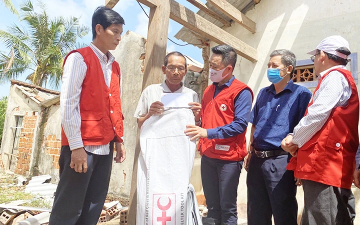 Lãnh đạo Hội Chữ thập đỏ Việt Nam trao bộ dụng cụ sửa nhà tặng người dân bị thiên tai.