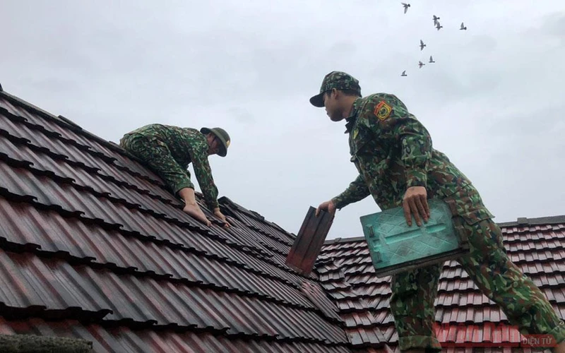 Bộ đội biên phòng Quảng Bình giúp người dân huyện Bố Trạch lợp lại nhà.