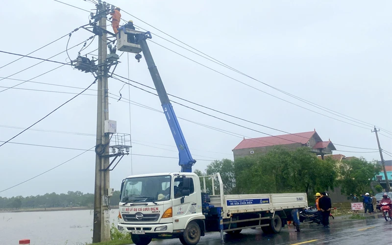 Công nhân Công ty Ðiện lực Quảng Bình khắc phục sự cố lưới điện sau bão số 13. Ảnh: HƯƠNG GIANG