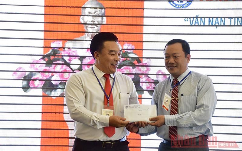 Chủ tịch Hội Nhà báo tỉnh Khánh Hòa Đoàn Minh Long (trái) trao khoản tiền 10 triệu đồng do Hội thảo quyên góp cứu trợ đồng bào miền trung bị bão lụt.