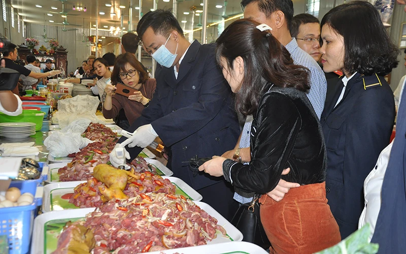 Cơ quan chức năng TP Hà Nội lấy mẫu thức ăn để kiểm nghiệm an toàn thực phẩm.