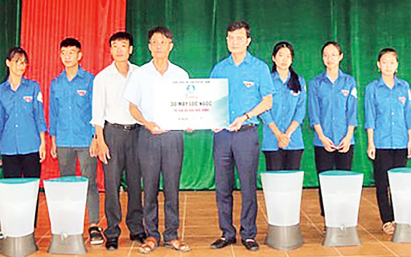 Đại diện T.Ư Hội Sinh viên Việt Nam trao tiền và máy lọc nước tặng người dân xã Tân Ninh (huyện Quảng Ninh, tỉnh Quảng Bình).