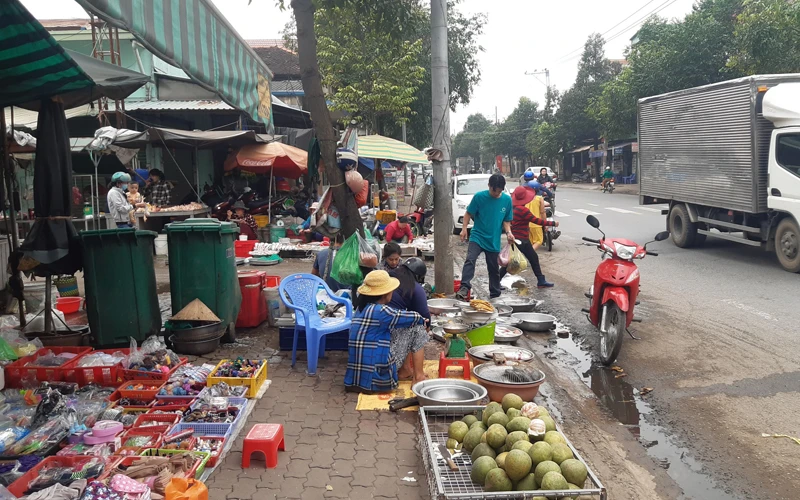 Nhiều tiểu thương chợ Tân Hạnh tràn ra lề đường tỉnh lộ 16 buôn bán, gây mất an toàn giao thông.