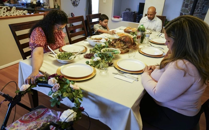 Một gia đình tại TP New York, Mỹ, cầu nguyện trước bữa ăn trong Lễ Tạ ơn, ngày 26-11. (Ảnh: AP)