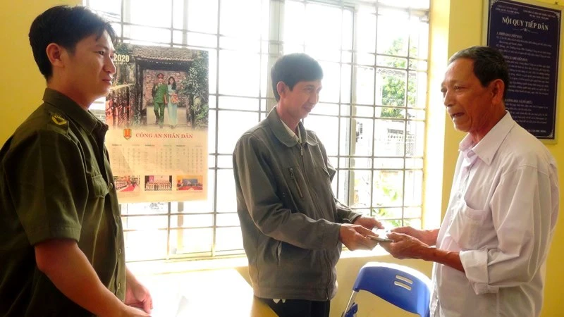 Ông Nguyễn Văn Thái (đứng giữa) trao trả tài sản cho ông Sơn dưới sự chứng kiến của Công an xã. 