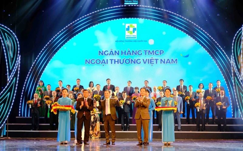 Đại diện Vietcombank, ông Lê Hoàng Tùng, Kế toán trưởng nhận biểu trưng Thương hiệu quốc gia cùng hoa chúc mừng từ Bộ trưởng Công thương Trần Tuấn Anh và đại diện Hội đồng Thương hiệu Quốc gia.