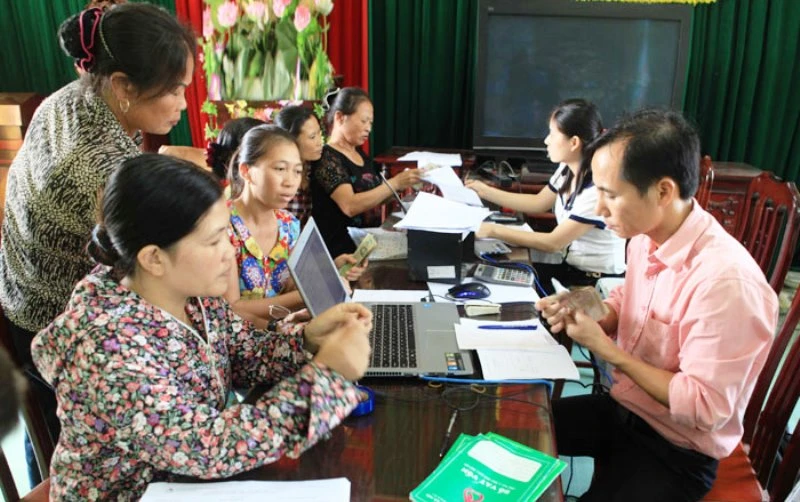 Cán bộ Ngân hàng Chính sách xã hội TP Hà Nội giúp người dân làm thủ tục vay vốn.
