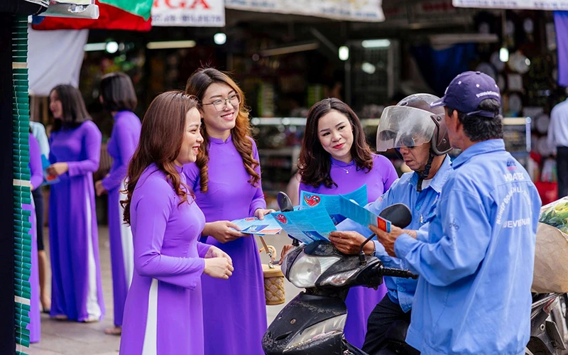 Đoàn viên công đoàn cơ sở Bảo hiểm xã hội tỉnh phát tờ rơi tuyên truyền chính sách bảo hiểm xã hội tại chợ Đông Ba.