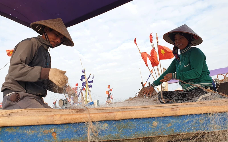 Người dân đan lưới ở ven biển huyện Hải Hậu.