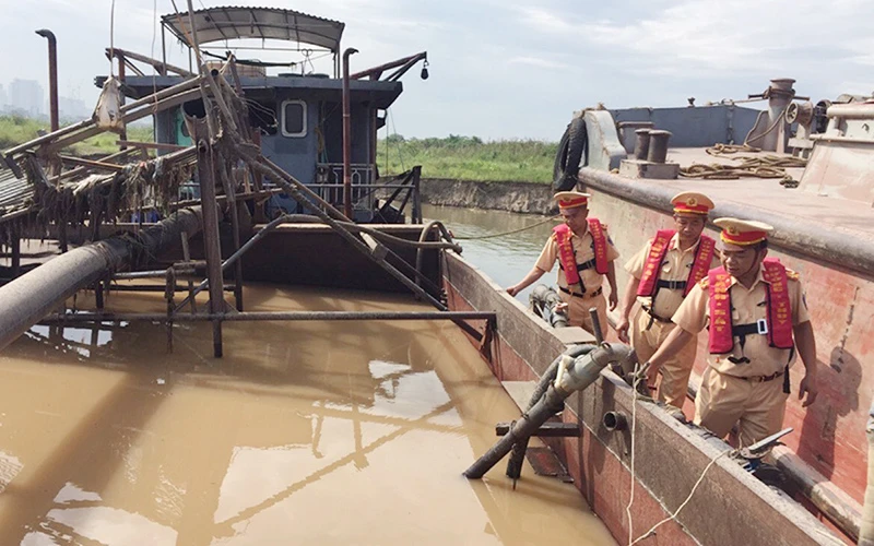 Lực lượng chức năng triệt phá tụ điểm khai thác cát trái phép trên tuyến sông Hồng, đoạn qua xã Võng La, huyện Ðông Anh. Ảnh: MINH HẢI