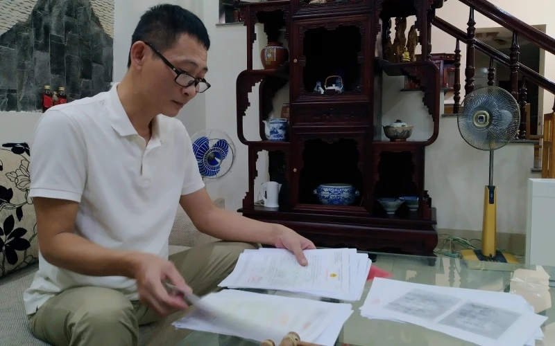 Anh Mai Hồng Quang sửa soạn hồ sơ đền bù di dời.