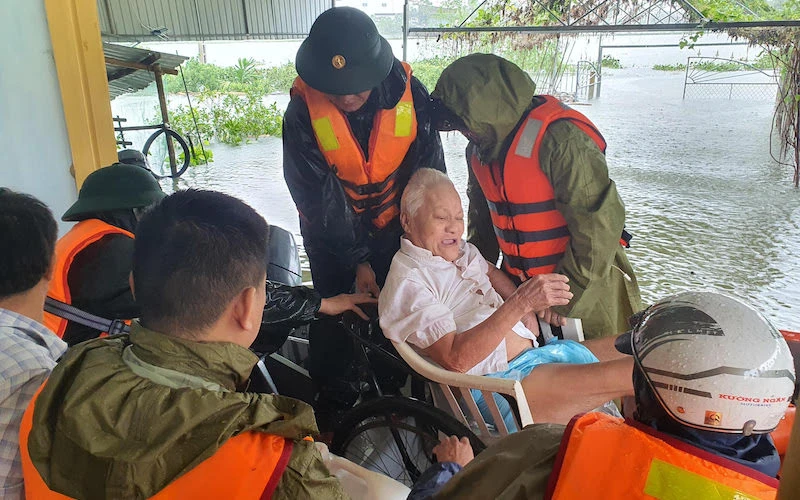 Công an huyện Thạch Hà giúp dân sơ tán trong mưa lũ. (Ảnh: NGÔ TUẤN)