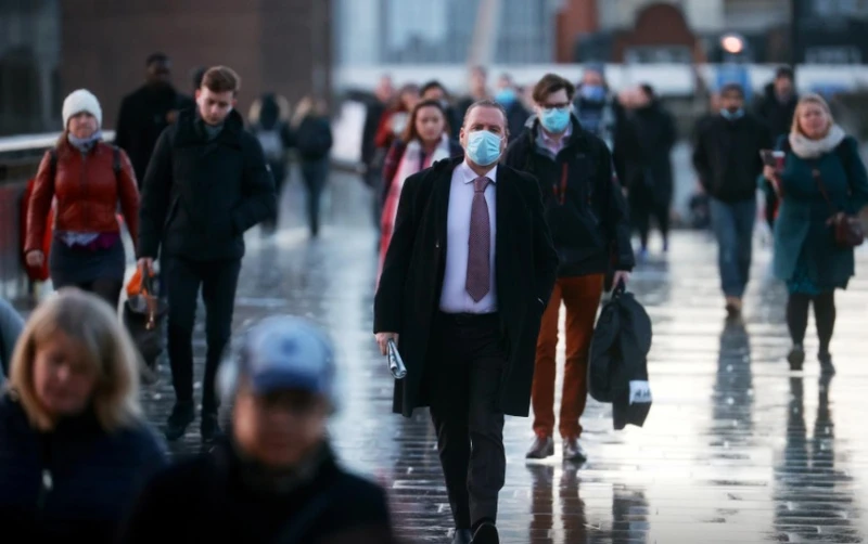 Người dân Anh đi bộ qua cầu London ngày 15-12 trong khi virus SARS-CoV-2 vẫn đang lây lan nhanh chóng. Ảnh: Reuters.