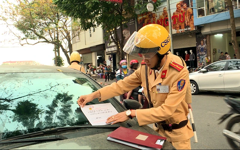 Cảnh sát giao thông TP Vĩnh Yên (Vĩnh Phúc) sử dụng hình thức dán giấy thông báo vi phạm đối với xe ô-tô.