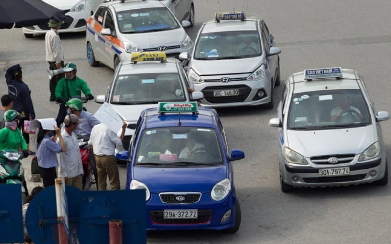 Các xe taxi thường xuyên tập trung chèo kéo khách gây ùn tắc, mất an toàn giao thông khu vực cổng vào Bệnh viện Bạch Mai.