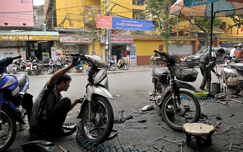 Cửa hàng sửa chữa xe máy chiếm dụng vỉa hè tại một con phố ở Hà Nội. Ảnh: Anh Sơn