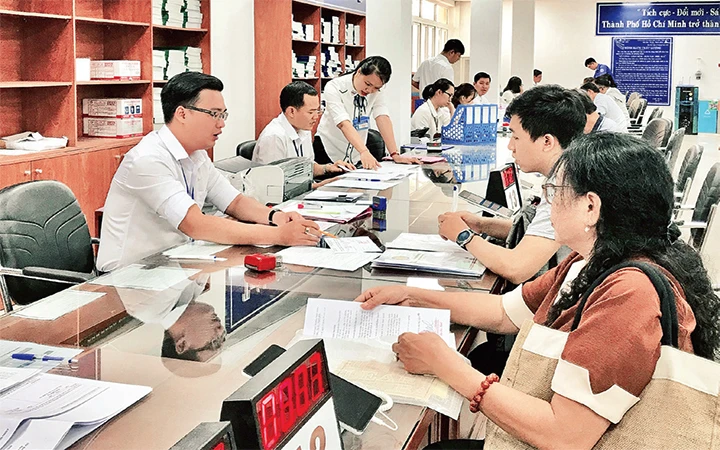 Cán bộ bộ phận tiếp nhận và trả hồ sơ quận Thủ Đức (TP Hồ Chí Minh) giải quyết hồ sơ cho người dân. Ảnh: KIỀU PHONG