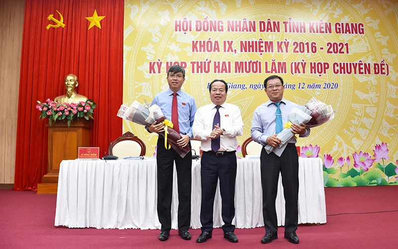 Ông Nguyễn Lưu Trung (trái) nhận hoa chúc mừng của Thường trực HĐND tỉnh Kiên Giang.