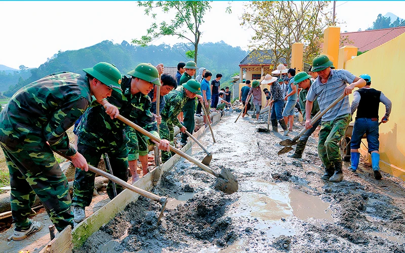 Cán bộ, chiến sĩ Ðồn Biên phòng Bảo Lâm (huyện Cao Lộc) giúp dân làm đường giao thông về thôn, bản.