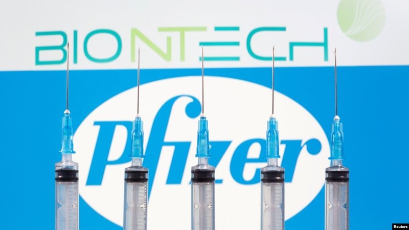 Ống tiêm được nhìn thấy trước logo Biontech và Pfizer được chụp vào ngày 10-11-2020. Ảnh: Reuters.