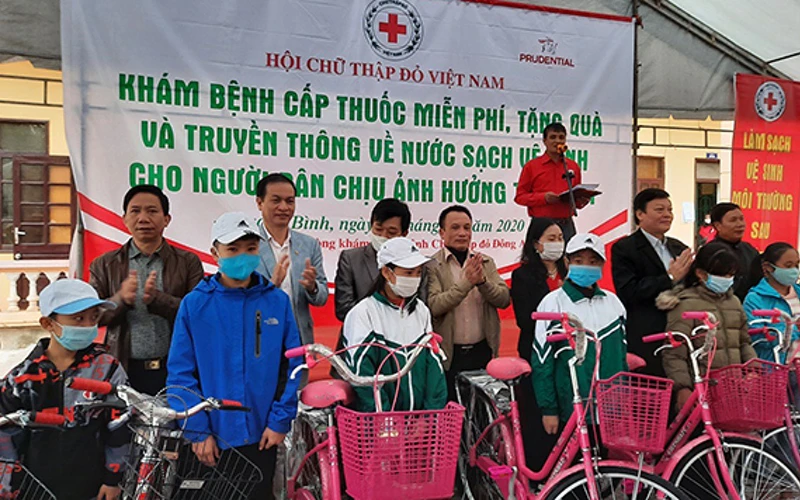 Đại diện Hội Chữ thập đỏ Việt Nam cùng các nhà tài trợ trao quà tặng học sinh có hoàn cảnh khó khăn do mưa lũ tại tỉnh Quảng Bình. Ảnh: PHƯƠNG DUNG