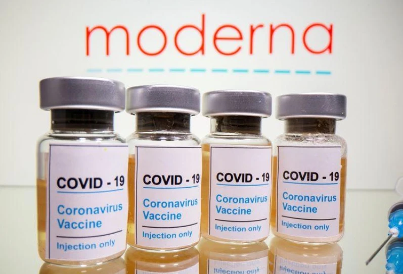 Lọ vaccine Covid-19 được đặt phía trước biểu trưng Moderna được chụp vào ngày 31-10-2020. Ảnh: Reuters.