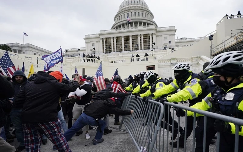 Người biểu tình ủng hộ ông Trump tìm cách phá vỡ rào chắn của cảnh sát để xông vào tòa Quốc hội, ngày 6-1. (Ảnh: AP)