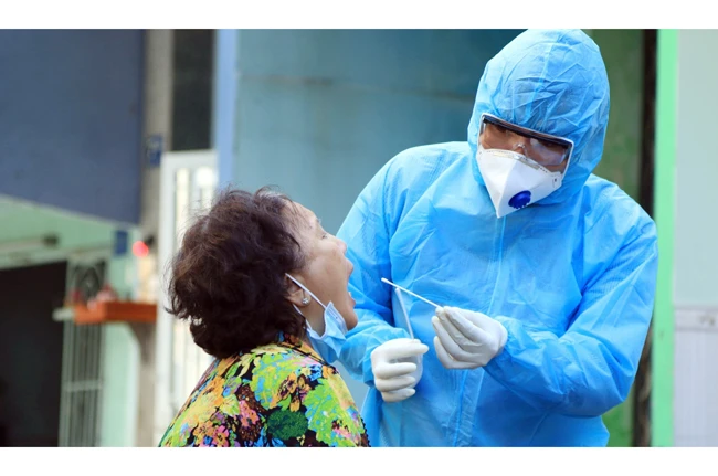Nhân viên y tế lấy mẫu xét nghiệm người dân trong khu vực Lô E, Lò Gốm (phường 7, quận 6, TP Hồ Chí Minh). Ảnh: ĐINH HẰNG
