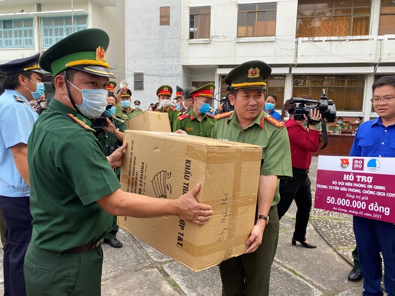 Đại tá Đinh Văn Nơi (trái) trao tặng khẩu trang y tế cho các chiến sĩ tham gia phòng, chống dịch trên tuyến biên giới.