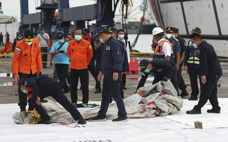 Lực lượng cứu hộ kiểm tra các mảnh vỡ được tìm thấy dưới nước ngoài khơi đảo Java. (Ảnh: AP)