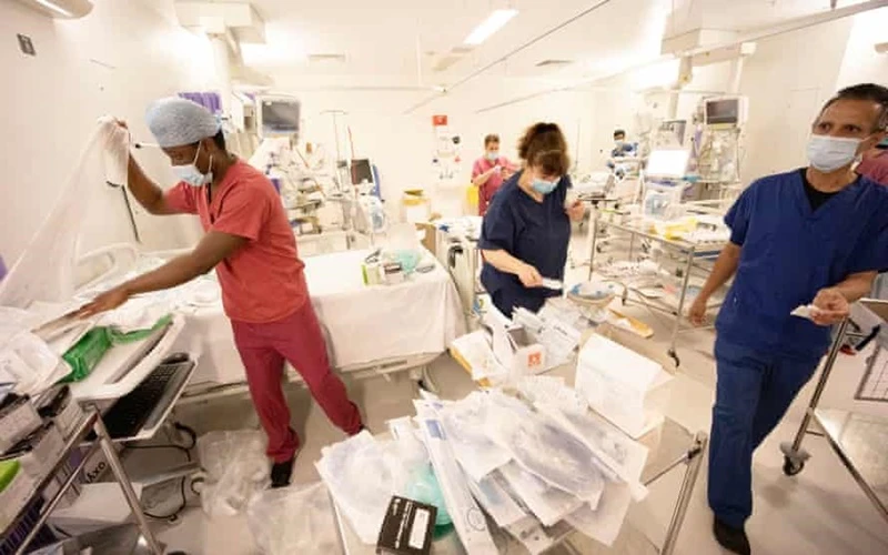 Nhân viên y tế tại một bệnh viện ở London, Anh, chuẩn bị giường cho người bệnh Covid-19 cần điều trị tích cực. (Ảnh: Guardian)