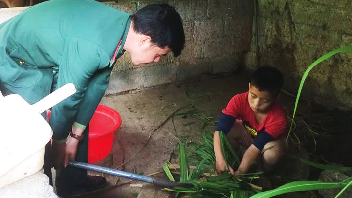 Cháu Mùa Văn Minh phụ giúp việc chăn nuôi ở đồn biên phòng.